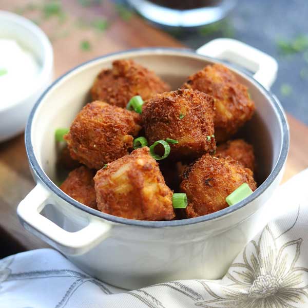 MBI Foods Loaded Baked Potato Fritters with sliced green onion served in a cocotte.